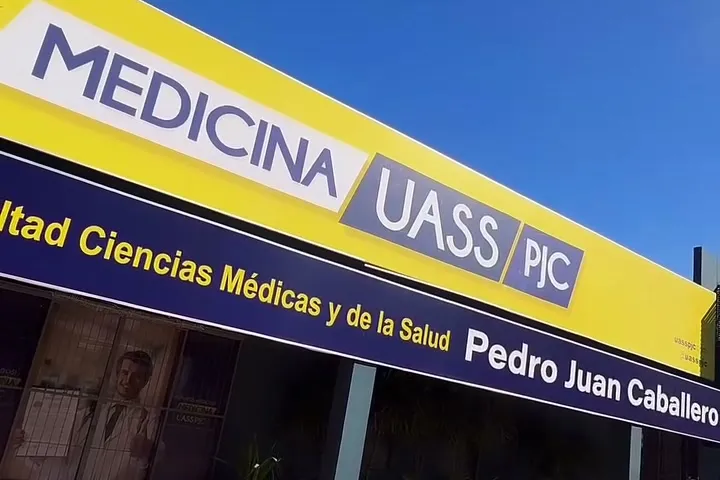 Fachada da sede da UASS-PJC, com o letreiro amarelo da Facultad de Ciencias Médicas y de la Salud em Pedro Juan Caballero