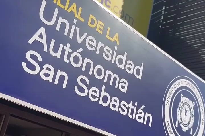 Placa na entrada da sede, com os dizeres Filial de la Universidad Autónoma San Sebastián e o brasão da universidade